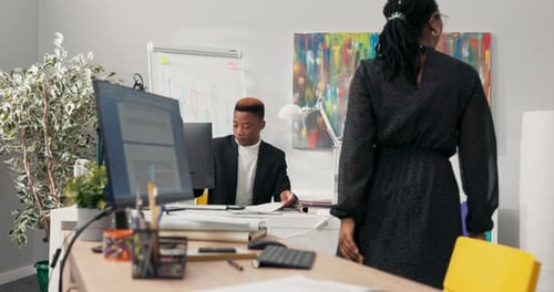 The Manager Boss Office Director with Dark Skin Dressed in Black Suit Sits Behind Desk Prepares
