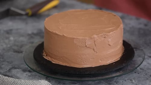Nahaufnahme von Frauenhänden beim Backen von süßem Kiewer Kuchen mit Buttercreme