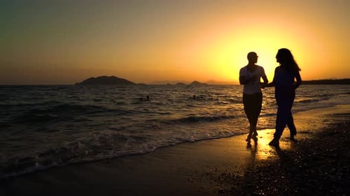 Romantic Couple Walking on Beach at Sunset