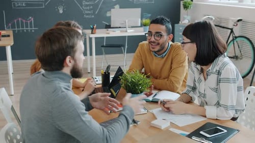 Male and Female Coworkers Doing High-five Sharing Ideas Working Together in Office