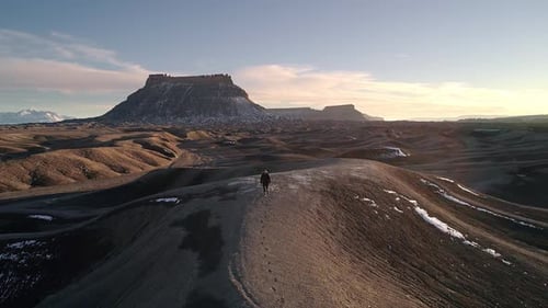 Man lost in the desert following his tracks over sand dune