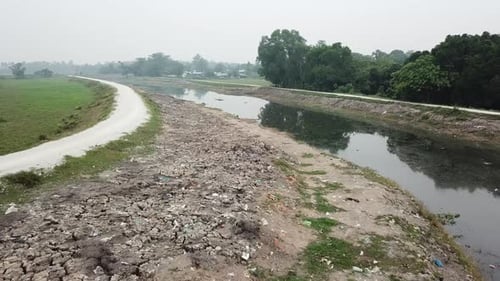 Rubbish scattered around at the crack land near polluted river