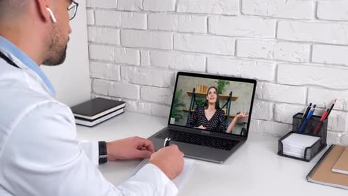 Doctor in hospital office listens patient client writes symptoms in notebook