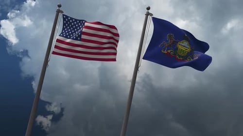 United States and Pennsylvania Flags Waving Under Cloudy Sky