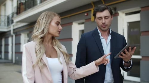 Closeup Couple Discussing Project at Street. Couple Using Tablet Outdoors