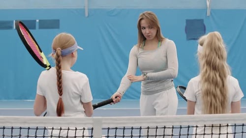 Tennis Instructor Demonstrates Proper Technique to Eager Students