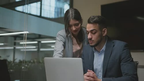 Young Woman Employee Explaining Project to Her Middle Eastern Boss Reading Business Analytics on