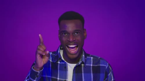 Black Guy Pointing Finger Up Having Idea Over Purple Background