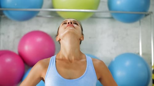 Woman Doing Neck Stretches in Gym