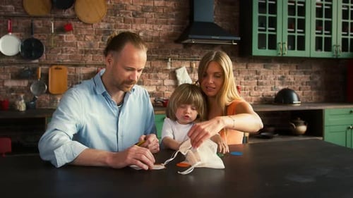 Parents and Son are Reading Kids Magazine or Telling Story to a Kid Sitting on Couch in Studio