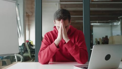 Pensive Man with Dark Hair Thinking in Office