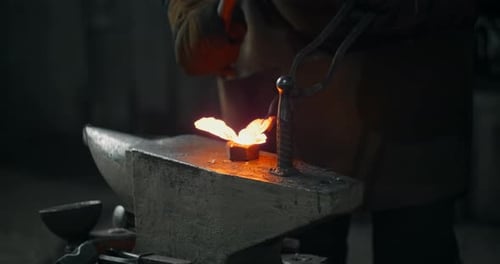Blacksmith Shapes Molten Metal on Anvil
