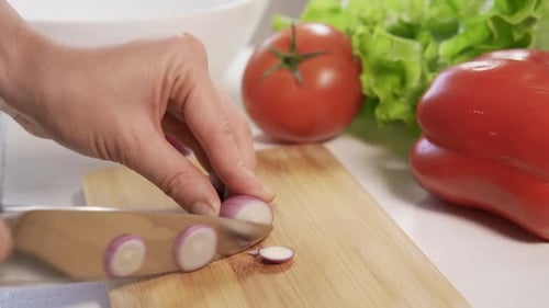 Slicing Shallots With a Knife on Cutting Board