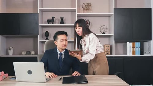 Business Colleagues Discussing Data on Tablet in Office