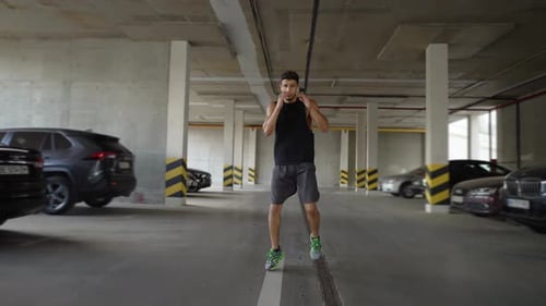 Male Boxer Practicing Punches in Garage City