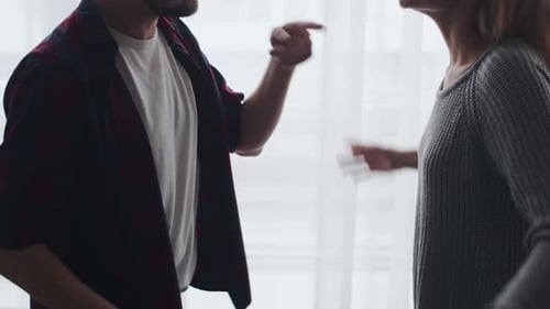 Man and Woman Having Tense Discussion Indoors