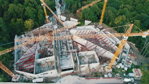 Aerial View Construction of a New Building with High Tower Cranes in Green Area