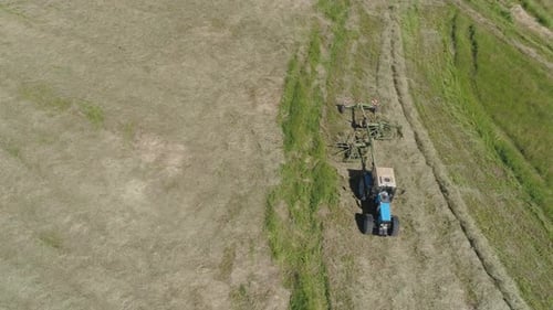 Trator com Rake Tedders no campo da fazenda.