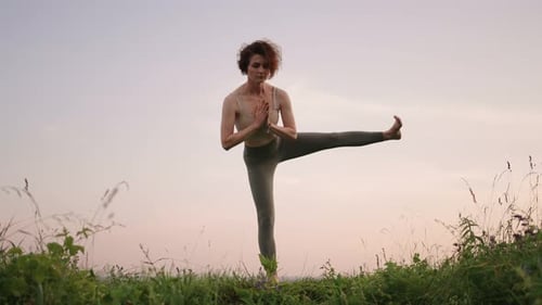 Woman Doing Yoga Outdoors During Sunrise