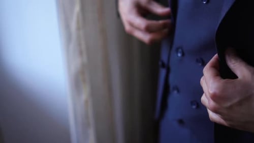 Groom Fastening His Jacket Before the Wedding Ceremony