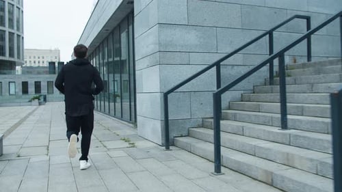 Sporty Man Running Down Stairs Outdoor. Fitness Man Training Run Exercise