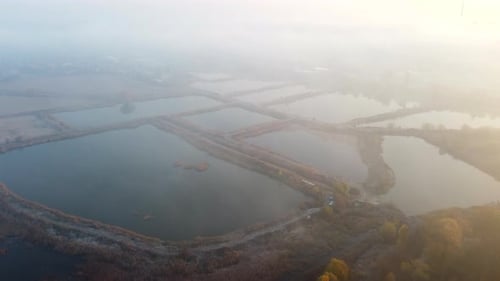 Survol aérien Drone au-dessus d'étangs creusés artificiellement pour la pisciculture en automne