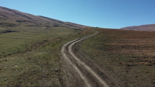 Rolling Hills and Dirt Road in Rural Landscape