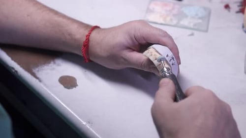 Dental Technician Works on Plaster Cast of Teeth