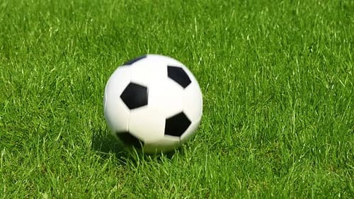 Football ball bouncing on green grass field