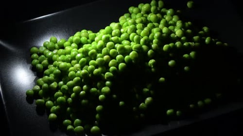 Heap of Fresh Green Peas on Black Plate