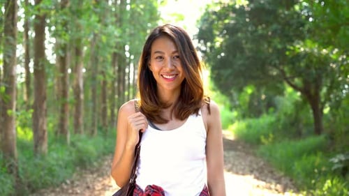 Young Asian woman traveler with backpack walking in forest.Adventure backpacker travel people.
