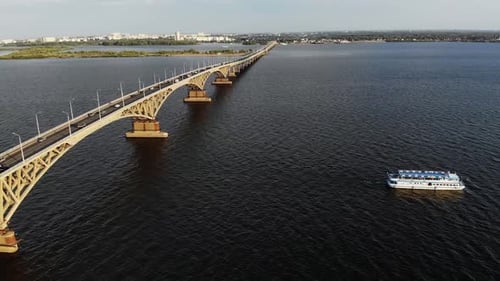 Aerial Shot on the Traffic on the Bridge with Ship Going Down the River