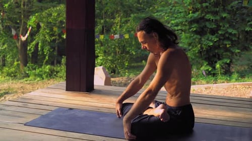 Yogi Sitting on a Mat in the Park and an Exercise