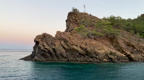Mountain cliff and rocky island in blue sea landscape. Blue sea water and rocky cliff on shore. Rock
