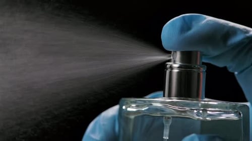 Spraying Clear Perfume Bottle in Close Up