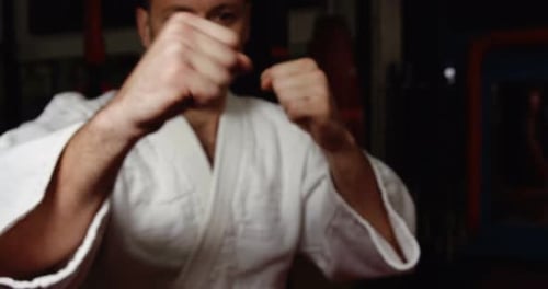 Man Demonstrating Punches in White Karate Uniform