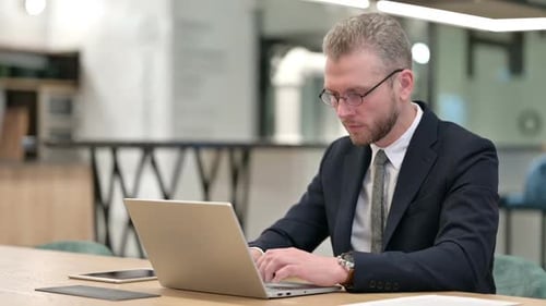 Professional Man Working on Laptop in Office