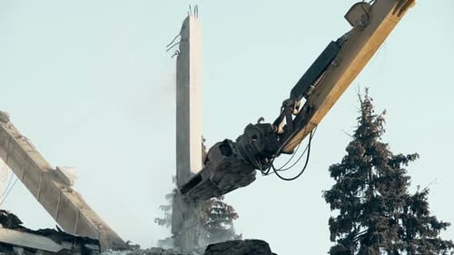 Machine de démolition de grande portée ruinant le bâtiment abandonné, déblayant le site de
