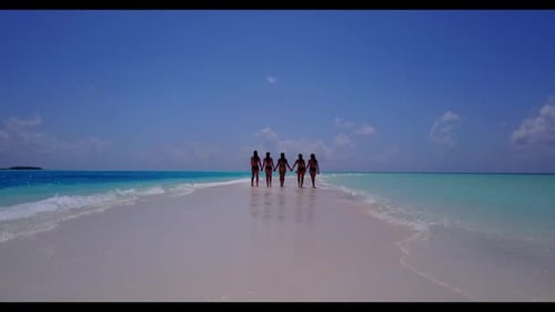 Ladies together happy and smiling on tropical tourist beach adventure by blue water with bright sand
