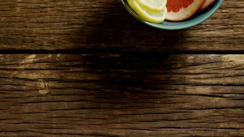 Bowl of Fresh Citrus Fruit on Wooden Surface