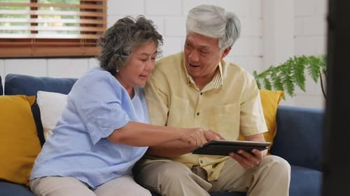 Mature Couple Enjoying Tablet Technology Together at Home