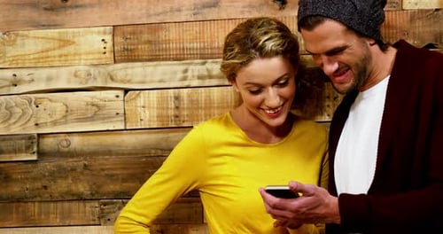 Couple using mobile phone in cafe