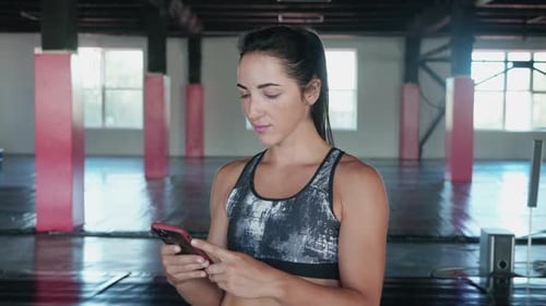 Fitness Guru Using Smart Phone in Gym