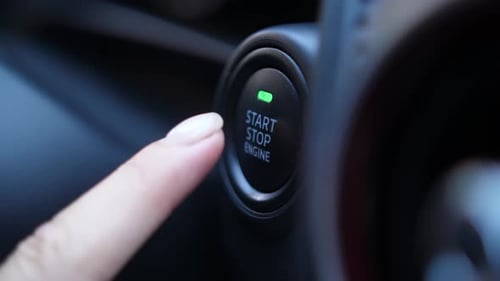 Weiblicher Finger drückt Start- oder Stopp-Motortaste
