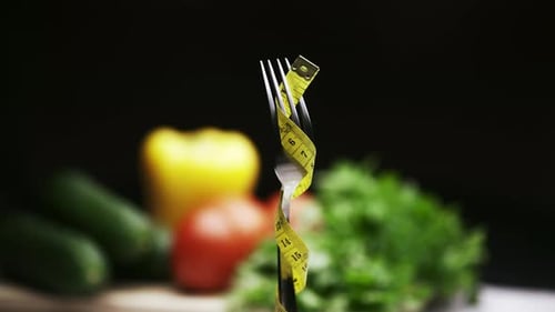 Fork with measuring tape with blurred vegetables