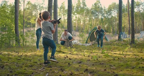 A Boy Collects and Wears Sticks for a Campfire During a Hike. Forest Caster for Cooking and Frying
