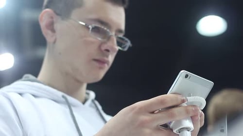 Young Adult Using Smartphone on Security Stand