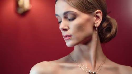 Elegant Woman Wearing Jewelry on Red Background
