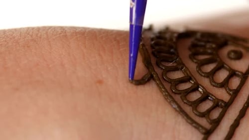 La mano de una mujer decorada con un tatuaje de henna, Mehendi, en blanco, de cerca