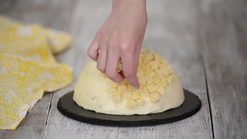 Une femme fait un gâteau traditionnel au mimosa à l'ananas